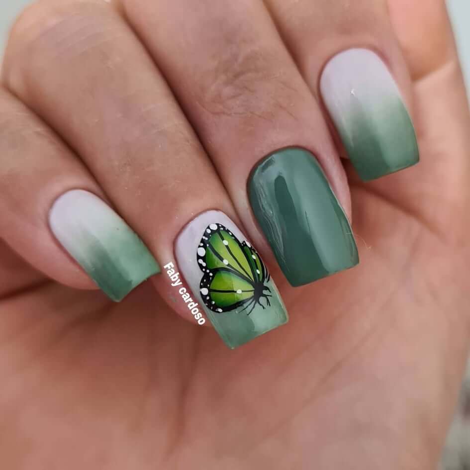 Unhas degradê verde com adesivo de borboleta