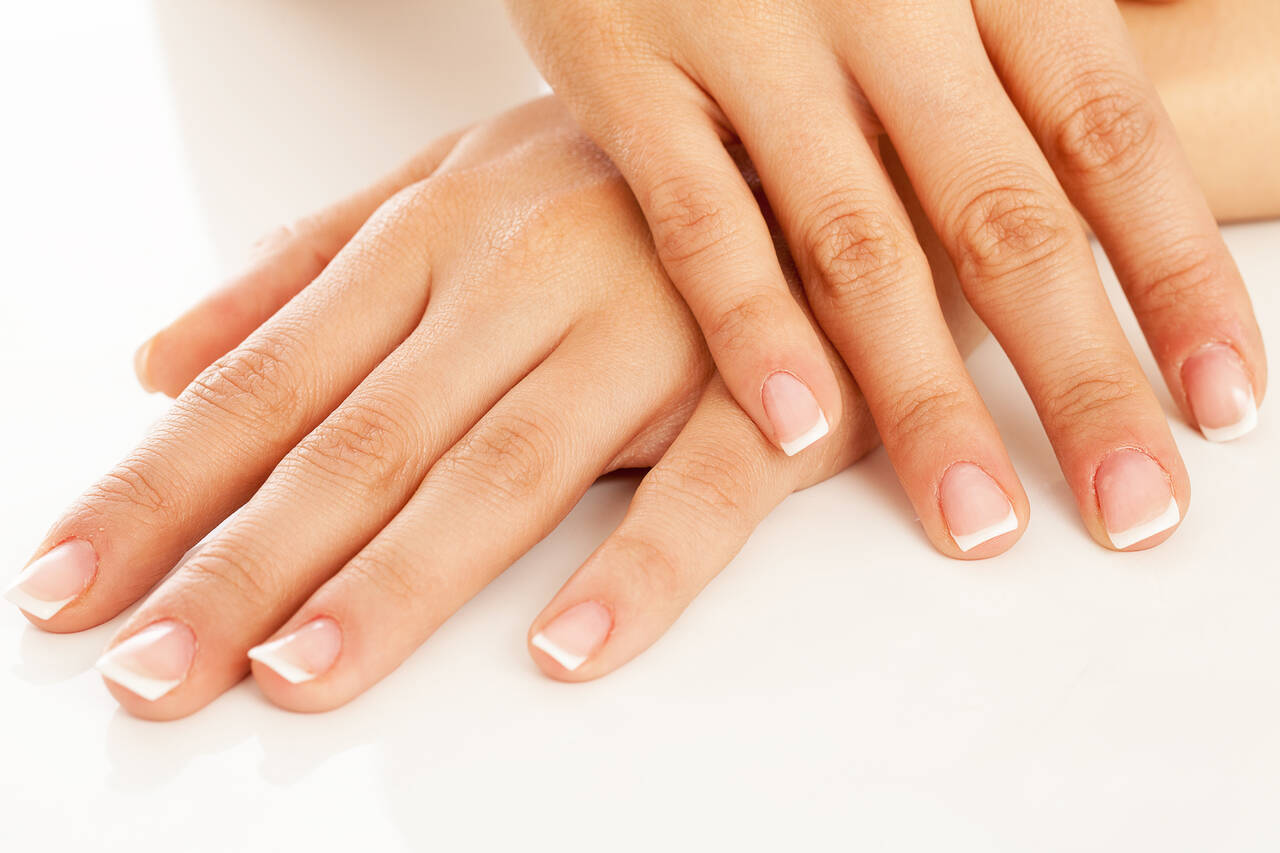 Close de mãos com manicure perfeita em unhas naturais 